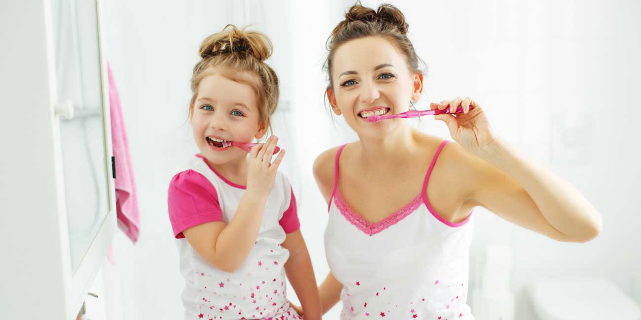 Happy Mother and Daughter are Brushing Their Teeth